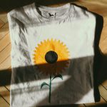 https://unsplash.com/photos/a-white-t-shirt-with-a-yellow-flower-painted-on-it-TWbEzeuIFzI?utm_content=creditShareLink&utm_medium=referral&utm_source=unsplash