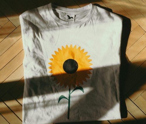 https://unsplash.com/photos/a-white-t-shirt-with-a-yellow-flower-painted-on-it-TWbEzeuIFzI?utm_content=creditShareLink&utm_medium=referral&utm_source=unsplash