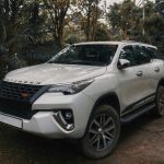 https://unsplash.com/photos/a-white-car-parked-on-a-dirt-road-with-trees-and-a-building-in-the-background-9Px9UR-wZkQ?utm_content=creditShareLink&utm_medium=referral&utm_source=unsplash