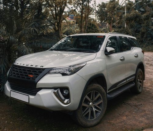 https://unsplash.com/photos/a-white-car-parked-on-a-dirt-road-with-trees-and-a-building-in-the-background-9Px9UR-wZkQ?utm_content=creditShareLink&utm_medium=referral&utm_source=unsplash